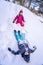Funny boy and girl in colorful winter suits climbs the snow hill. Kids play and jump in snowy forest. Child playing with
