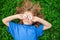 Funny Boy Kid and Daisies. Happy little blond hair child with flowers eyes laying on the grass with daisies flowers