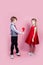 Funny boy and little girl with candy red lollipop in heart shape. Beautiful children eat sweets. Valentine`s day