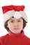 Funny boy with red hat of Christmas pulling a face