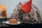 A funny British cat in a red cap on his head, a white shirt with a red bow tie sits at a table