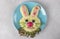 Funny bunny from mashed potato and sausages for breakfast kids meal on blue plate