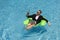 Funny business man in a business suit floating in the water in the pool. Remote work. Crazy freelancer. Business and