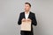 Funny business man holding brown clear empty blank craft paper bag for takeaway mock up isolated on grey background