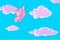 Funny cartoon pink smiling elephant flies in the sky with clouds