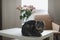 Funny cat and jug with flowers in light room. Cute cat, vase with roses, armchair in a cozy room. Interior decoration