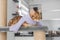 A funny cat in a scarf lies on a scratching post against the background of the room