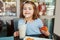 Funny Caucasian preschool toddler girl drinking milk shake in cafe.