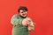 Funny charismatic young obese guy is having fun playing games on his mobile phone device, a man is excited and cheerful, totally