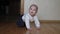 Funny Cheerful Caucasian Baby Learns To Crawl On All Fours On The Floor In House