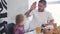 Funny cheerful tattooed man playing high five with little blond daughter at home. Portrait of happy joyful father