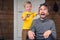 Funny child cutting hair to his father at home during quarantine lockdown. Little hairdresser barber makes haircut to his scared