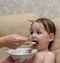 Funny child eating porridge delicious nutritious oatmeal