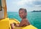 Funny child enjoying summer vacation on yellow rowing boat