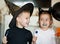 Funny child girl and boy in witch and evil costumes for Halloween eating candies lolly pops and have fun