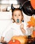 funny child girl in evil costume for Halloween eating candies lolly pop and have fun.