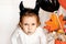 funny child girl in evil costume for Halloween eating candies lolly pop and have fun.