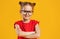 Funny child girl in glasses on colored background