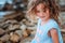 Funny child girl playing with water splash on the beach. Traveling on summer vacation.