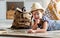 Funny child girl tourist with world map, backpack and magnifier