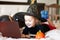 Funny child girl in witch costume for Halloween lies on the bed and using a digital tablet laptop notebook. Online call friends or