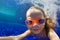 Funny child in goggles dive in swimming pool
