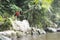 Funny child jumping high into waterfall.