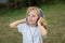 Funny child with long hair listening music with blue hadphones