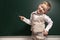 Funny child near chalkboard, space for text. First time at school