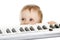 Funny child standing behind electronic piano