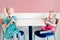 Funny children girls sitting together eating licking ice-cream with colorful sprinkles.