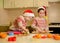 Funny children prepare holiday food for family. Santa chefs. Xmas