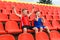 Funny children sit in the sports stands and cheer for the team. two brothers