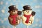 Funny chocolate snowmen candies against blurred festive lights, closeup