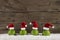 Funny christmas background with green balls and santa hats on wood.
