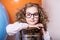 Funny, clever curly teen girl in glasses with wooden abacus on t