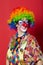 Funny clown with glasses on red