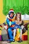 Funny clown with the little girl sit on a sofa.