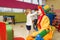 Funny clown play with little girl in kindergarten