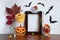 Funny composition with empty photo frame for Halloween holiday. Skeleton Zombie, Jack o Lantern, bats, mug with candy