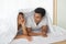 Funny couple lying, talking, hiding in white blanket on white bed  in the bedroom. Relation in family. Relaxing in the morning