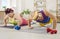Funny couple pushing up lying on the floor on yoga mat in sportswear at home.