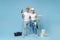 Funny couple woman man in helmet hardhat glasses hold paint bucket paint roller, electric drill isolated on blue