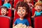 Funny curly-haired boy laughing out loud at the movie theater AI generated image