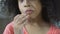 Funny curly-haired girl eating cookie at home, close-up of female child snacking