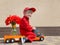 Funny cute 4 years old boy in a red mechanic overalls and a cap sitting on a toy truck with large bouquet of tulips