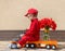 Funny cute 4 years old boy in red mechanic overalls and cap sitting on toy truck with a large bouquet of tulips