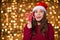 Funny cute girl in santa claus hat with christmas lollypops
