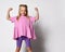 Funny cute little girl shows tense muscles on a white background. Look at my muscles