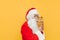 Funny and cute Santa Claus is hugging a stuffed reindeer toy, showing the toy to the viewers. Amusing Santa is playing with a